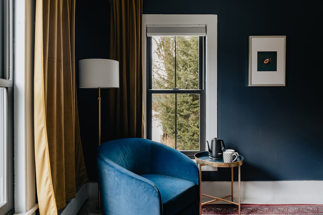 Comfortabele leesstoel bij het raam met een lamp en een kopje thee