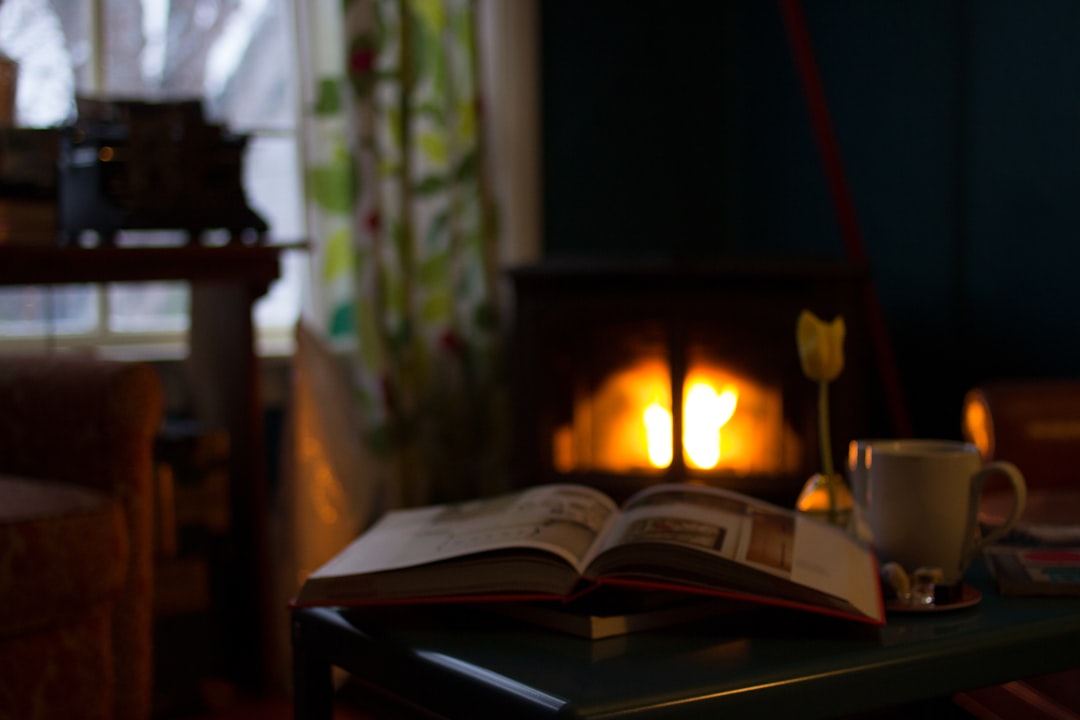Opengeslagen boek en dampende mok op tafel bij warm avondlicht